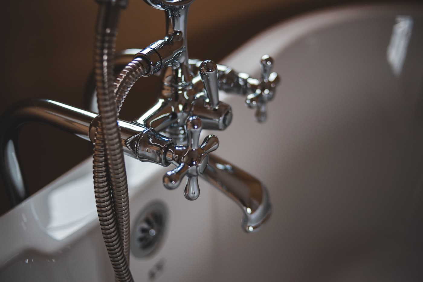 A chrome bath faucet and hand shower